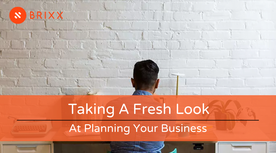 Blog post header image of a man working at a desk for the Taking a fresh look at planning your business post by Brixx software